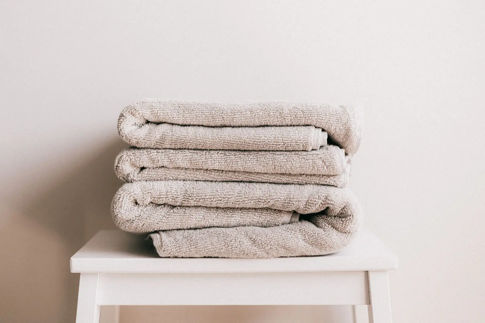 Folded towels stacked on a small white stool